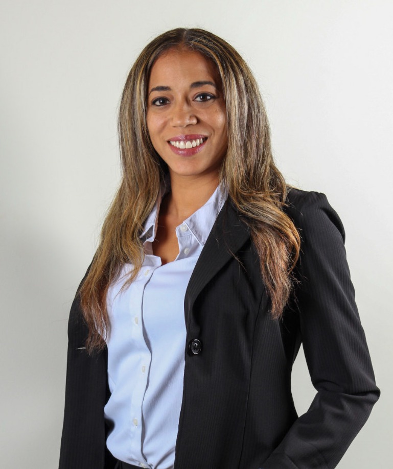 Yoena Paulino in a black suite and blue shirt smiling