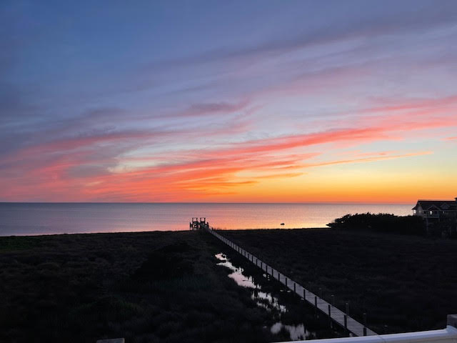 beach at sunset with walking deck to water